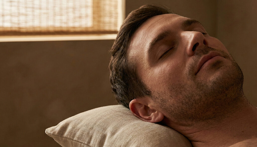 Zrelaksowany mężczyzna po masażu w MOA Wadowice. Głębokie odprężenie i skuteczna ulga w bólu.